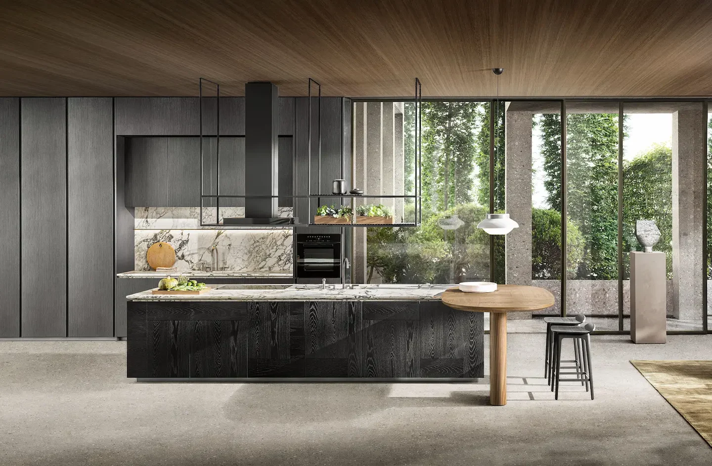 Cucina con isola in legno nero, piano di marmo venato, tavolino ovale color noce, sgabelli e vetrate sul giardino
